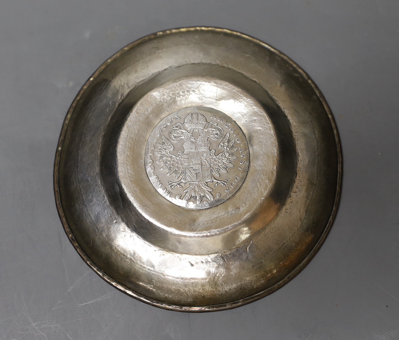 An engraved Middle Eastern? white metal dish with inset coin, 11.7cm, gross weight, 90 grams.